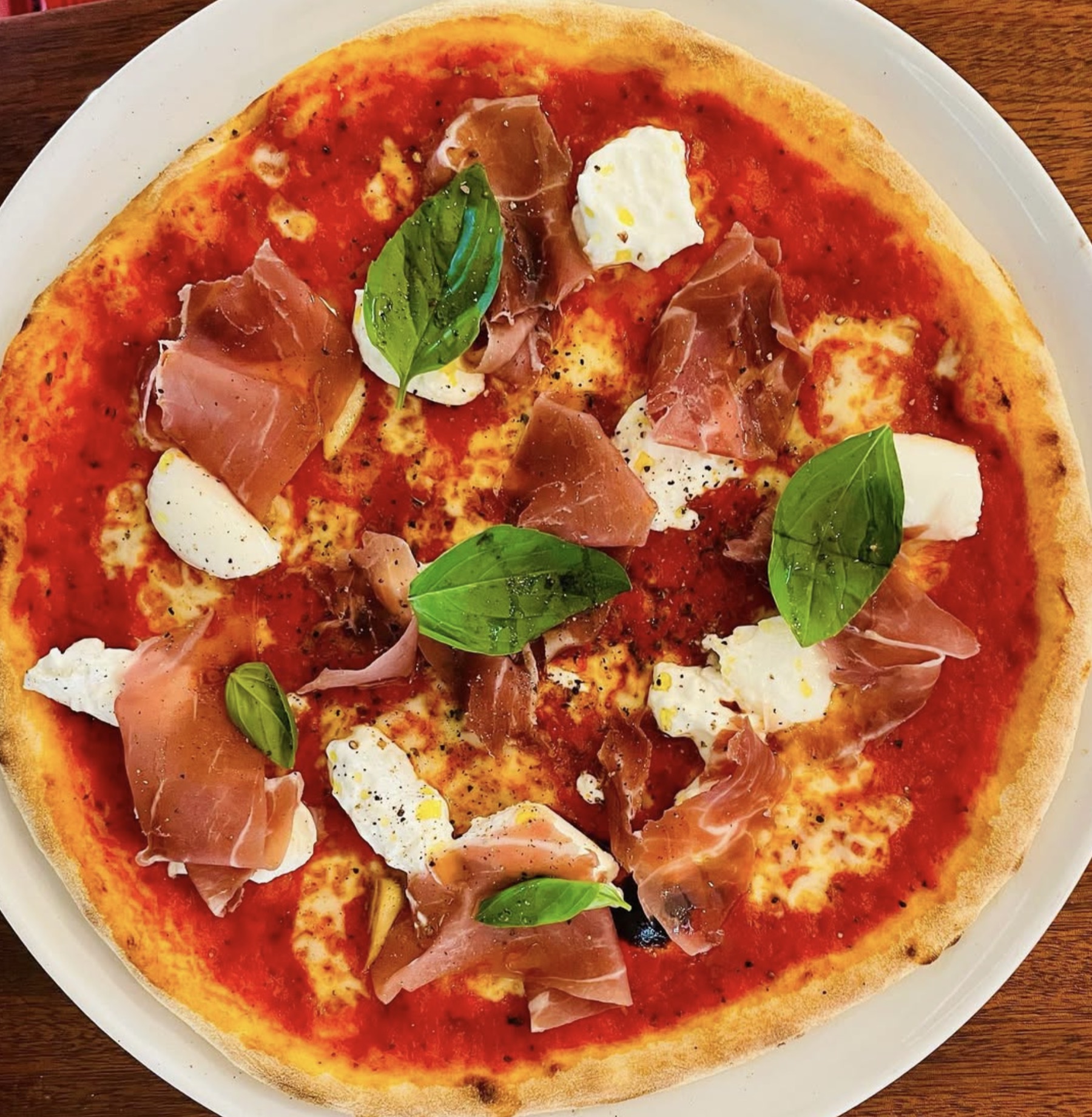 Pizza prosciutto, burrata et basilic